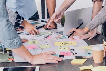 Office workers planning an event sticky notes and desk