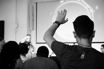 Person putting hand up in conference B&W