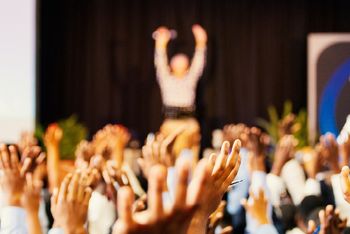 People putting hands up at a conference