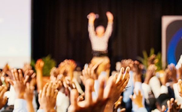 People putting hands up at a conference