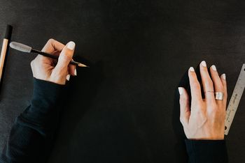 Hands with pen on black background