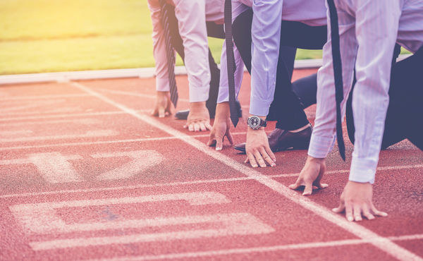 Business people on athletic track start line