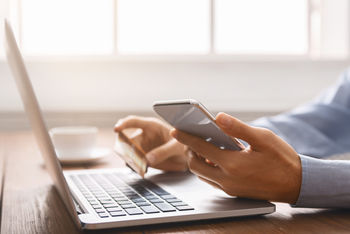 man using credit card at laptop blurred