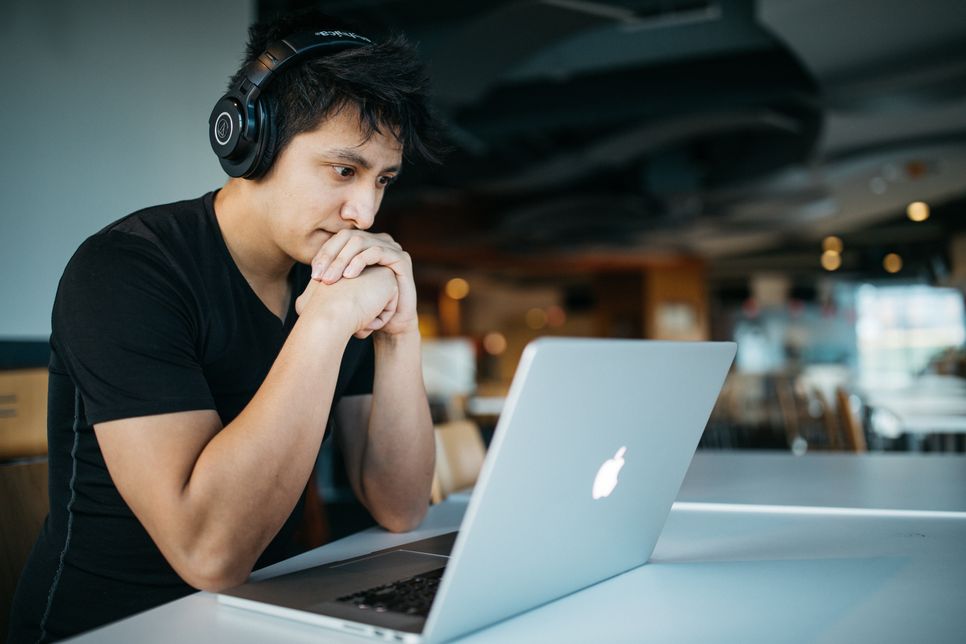 Young man at laptop wearing headphones 