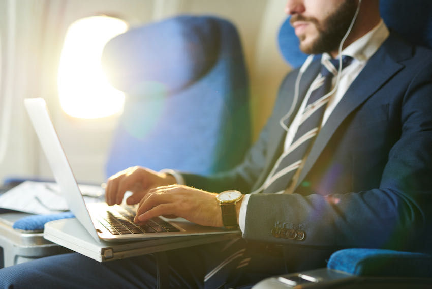 Man on plane with laptop