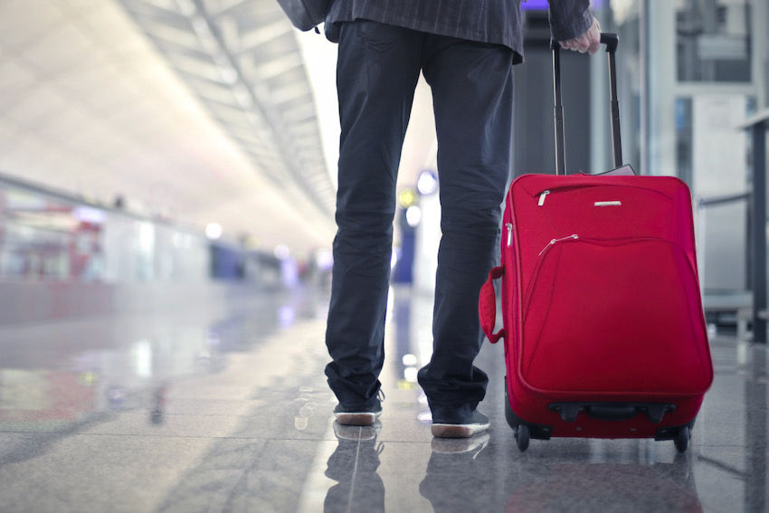 business traveller at airport red suitcase