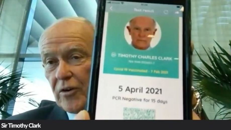 Clark, seen here giving attendees a look of his travel pass on mobile pass, said the digital health pass is the "first and right step" to reopen travel.