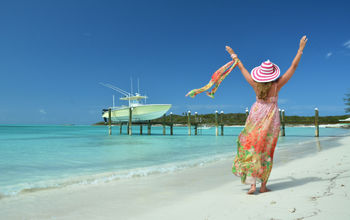 Woman on beach at Great Exuma, Bahamas (photo via astra490/iStock/Getty Images Plus)