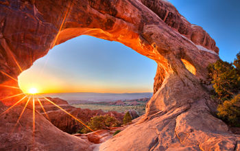 Sunrise at Partition Arch, in Arches National Park. (photo via tonda / iStock / Getty Images Plus)