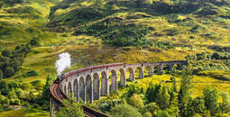 Glenfinnan Railway Viaduct in Scotland with the Jacobite steam train passing over (photo via miroslav_1 / iStock / Getty Images Plus(