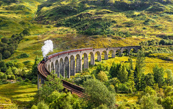 Glenfinnan Railway Viaduct in Scotland with the Jacobite steam train passing over (photo via miroslav_1 / iStock / Getty Images Plus(