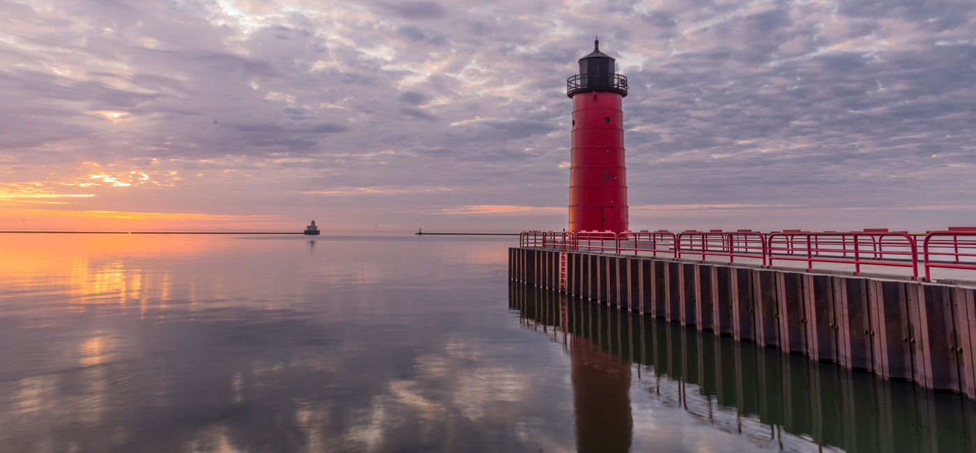 Image: Red lighthouse on Lake Michigan at sunrise in Milwaukee, WI (photo via AMCImages / iStock / Getty Images Plus)