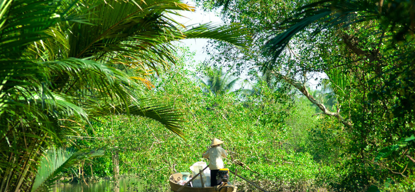 Image: PHOTO: A woman driving a boat in the Mekong Delta in Vietnam. (photo via MasterLu / iStock / Getty Images Plus)