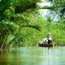 Woman driving a boat in the mekong delta. Vietnam. (photo via MasterLu / iStock / Getty Images Plus)