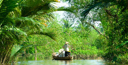 Woman driving a boat in the mekong delta. Vietnam. (photo via MasterLu / iStock / Getty Images Plus)