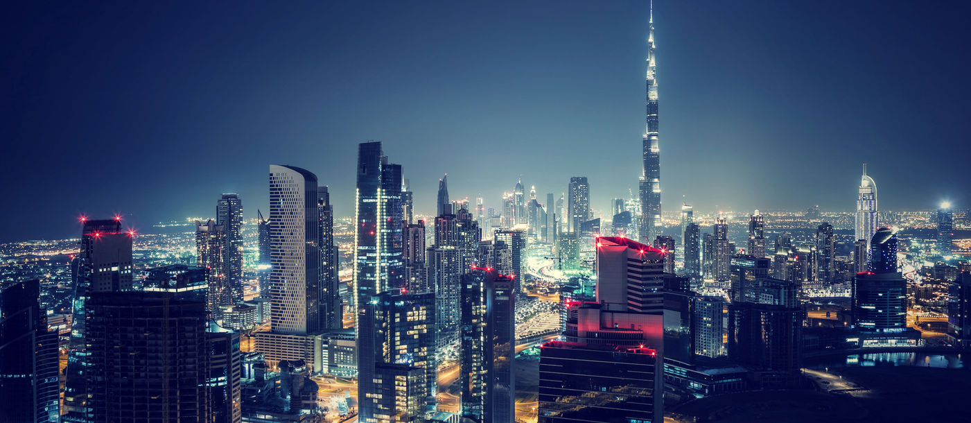 Beautiful Dubai cityscape, bird&#39;s eye view on a night urban scene, modern city panoramic landscape, United Arab Emirates (photo via Anna_Om / iStock / Getty Images Plus)