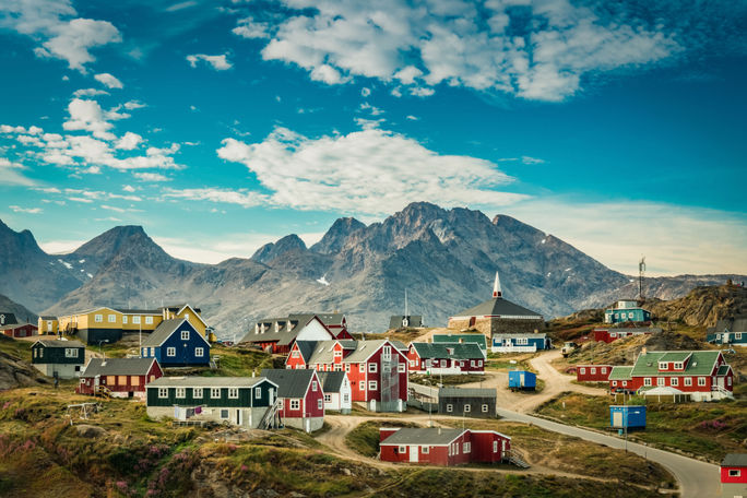 Picturesque village in Greenland with colorful houses view of a colorful village in Greenland (photo via Elizabeth M. Ruggiero/iStock/Getty Images Plus)