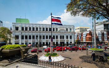 Town square in San Jose with Costa Rica flag (photo via Esdelval / iStock / Getty Images Plus)
