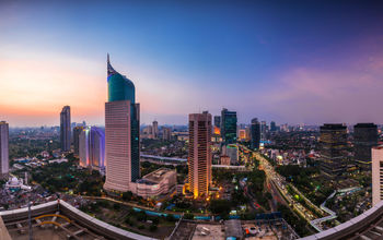 colorfull Jakarta Skyline at dawn with the iconic building. The building is one of the most highest building in Indonesia. (photo via AlfinTofler / iStock / Getty Images Plus)