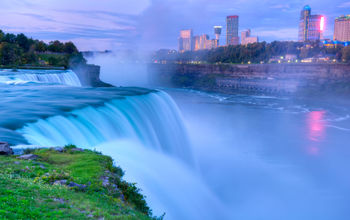 Niagara Falls from the American side with the skyline of the city of Niagara Falls, Canada, in the background.