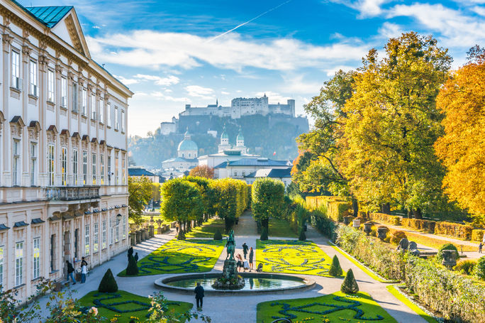 Famous Mirabell Gardens with historic Fortress in Salzburg, Austria Beautiful view of famous Mirabell Gardens with the old historic Fortress Hohensalzburg in the background in Salzburg, Austria (photo via bluejayphoto / iStock / Getty Images Plus)