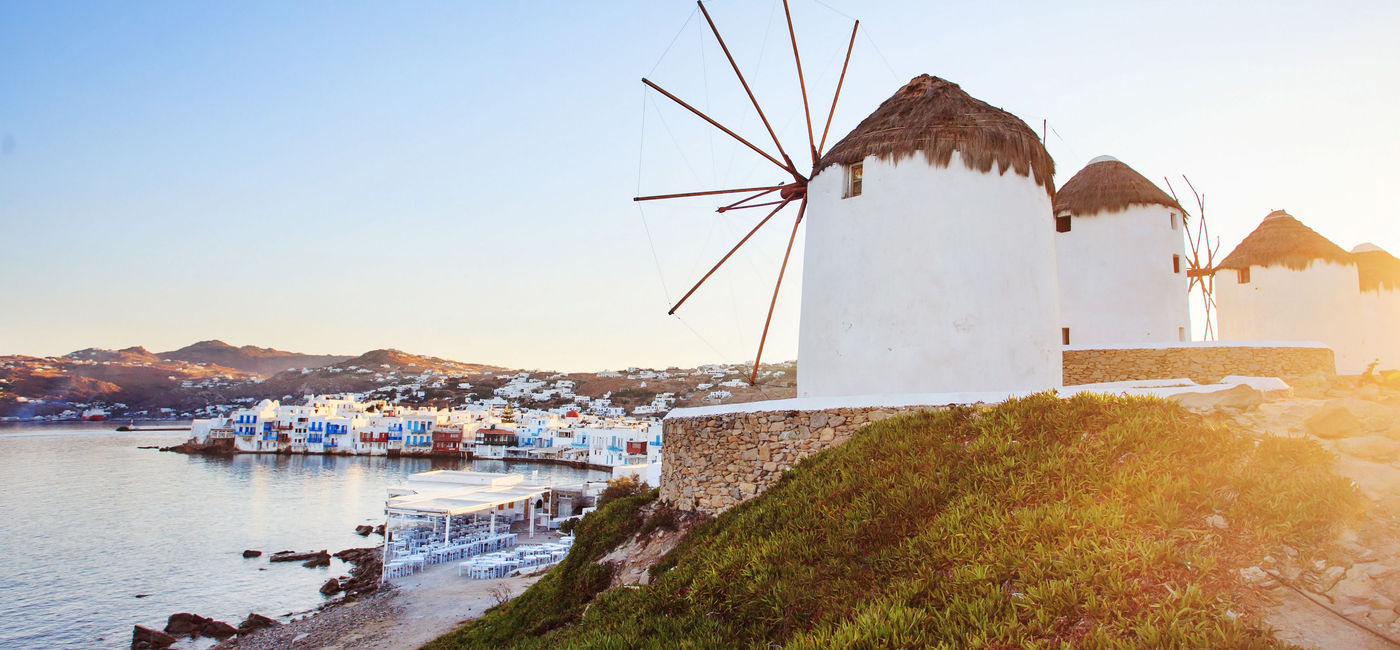 Image: Windmills of Mykonos, Greece with blue sky. (photo via JustinBlackStock / iStock / Getty Images Plus)