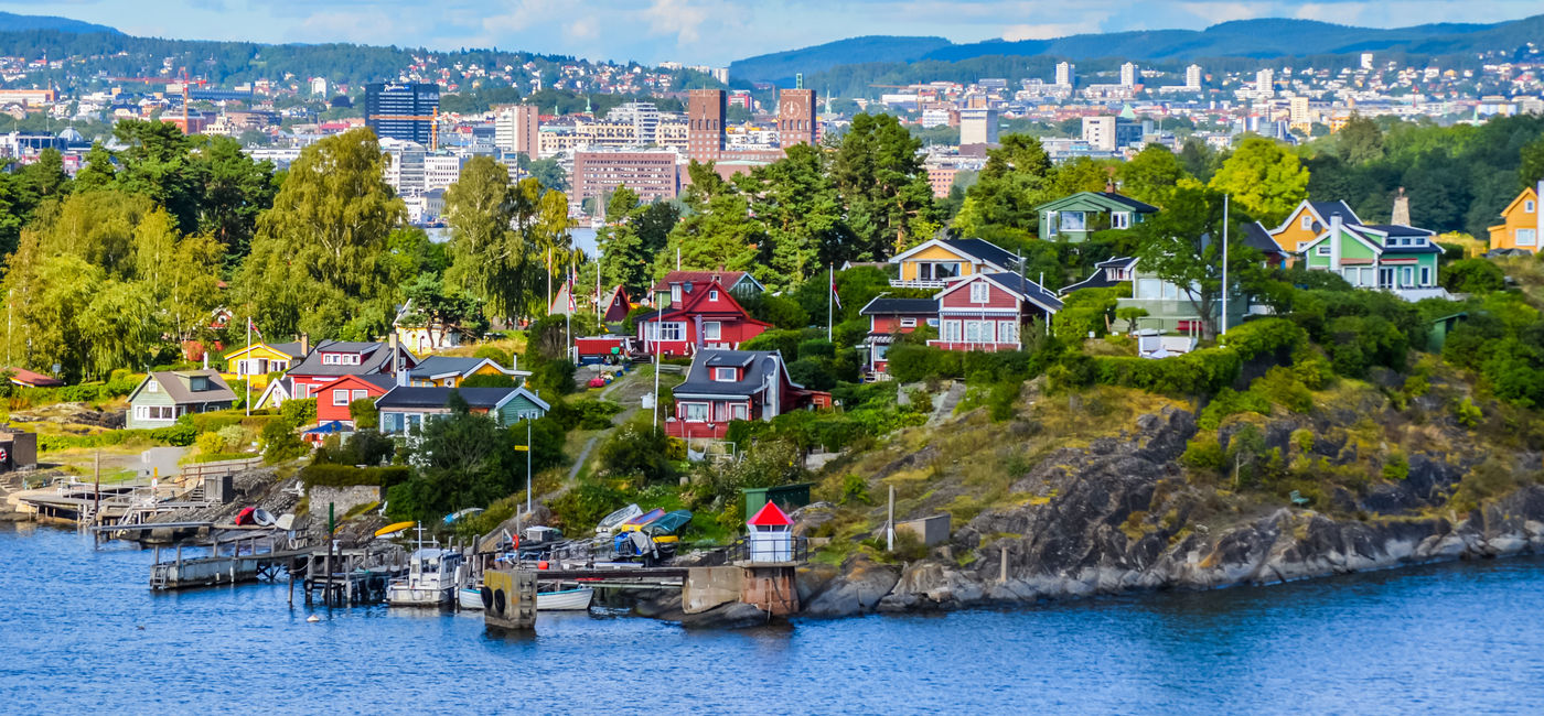 Image: View of Oslo between the city and typical Nordic cottages. (photo via Damien VERRIER / iStock / Getty Images Plus)