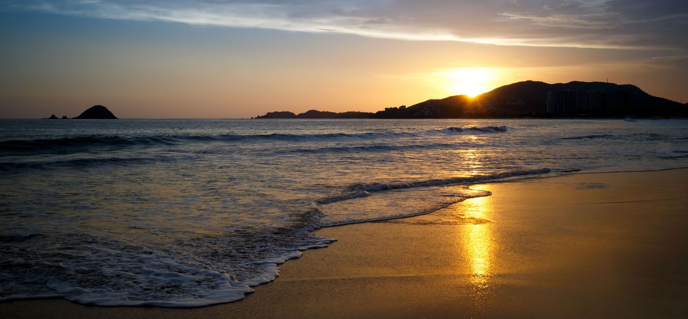 Image: PHOTO: Sunset at the beach. Ixtapa, Zihuatanejo, Mexico. (photo via ChepeNicoli / iStock / Getty Images Plus)