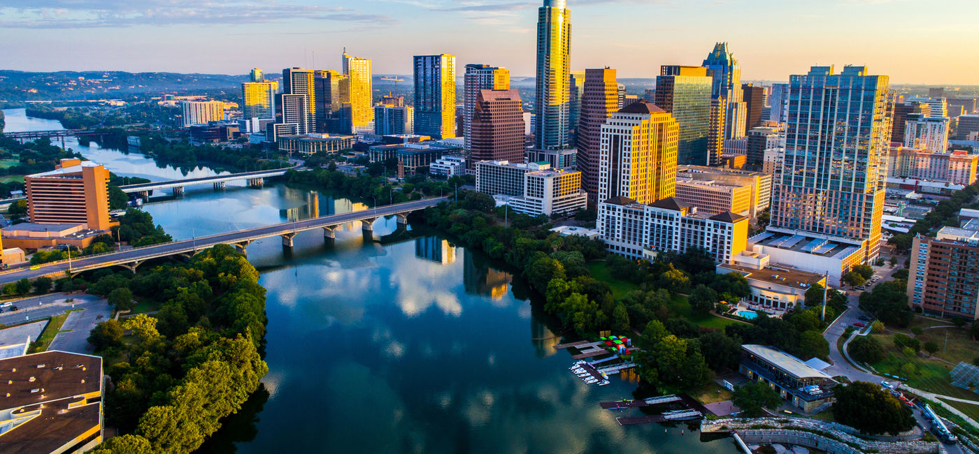 Image: PHOTO: Sunrise over Austin, Texas above tranquil Lady Bird Lake. (photo via RoschetzkyIstockPhoto / iStock / Getty Images Plus)