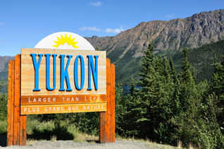 Yukon Territory, Canada Welcome Sign with Mountains in the Distance (photo via herreid / iStock / Getty Images Plus)