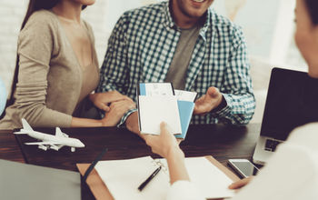 Travel agent handing tickets to clients