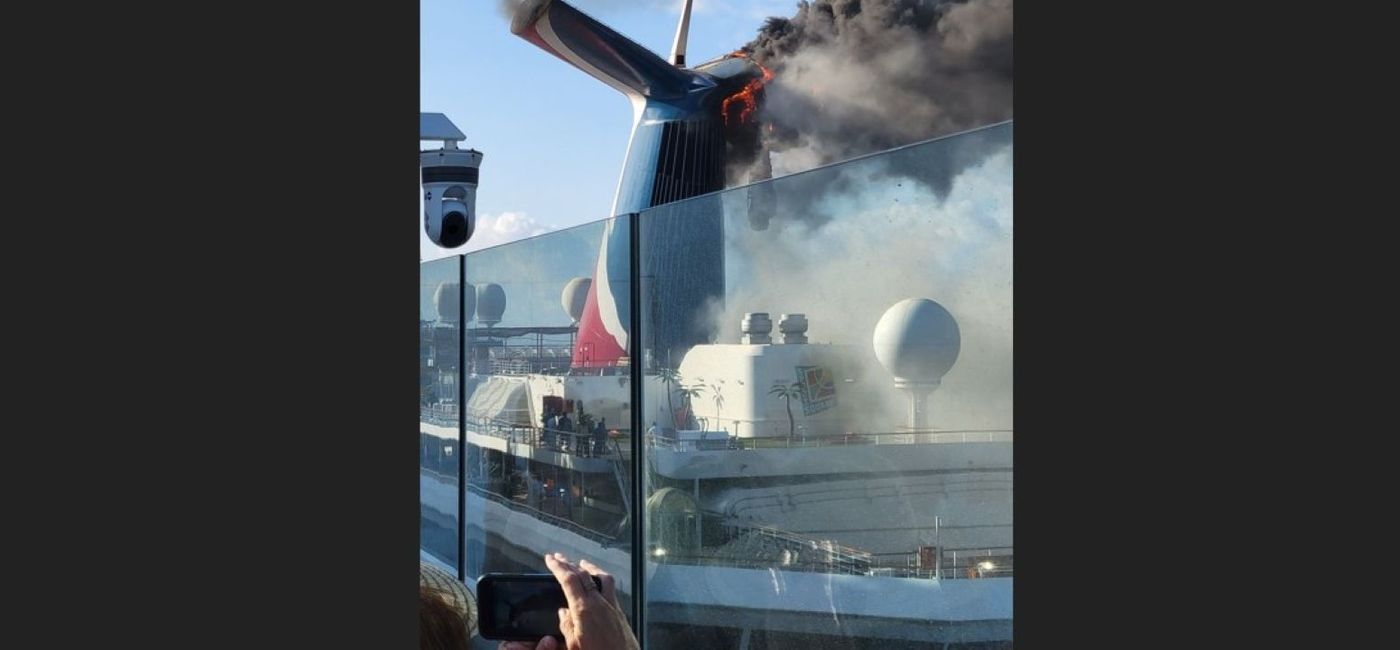 Image: Smoke billows from Carnival Freedom's red and blue funnel Thursday, May 26 when it was docked in Turks & Caicos. (photo via That Panda Guy / Twitter) ((photo via That Panda Guy / Twitter))