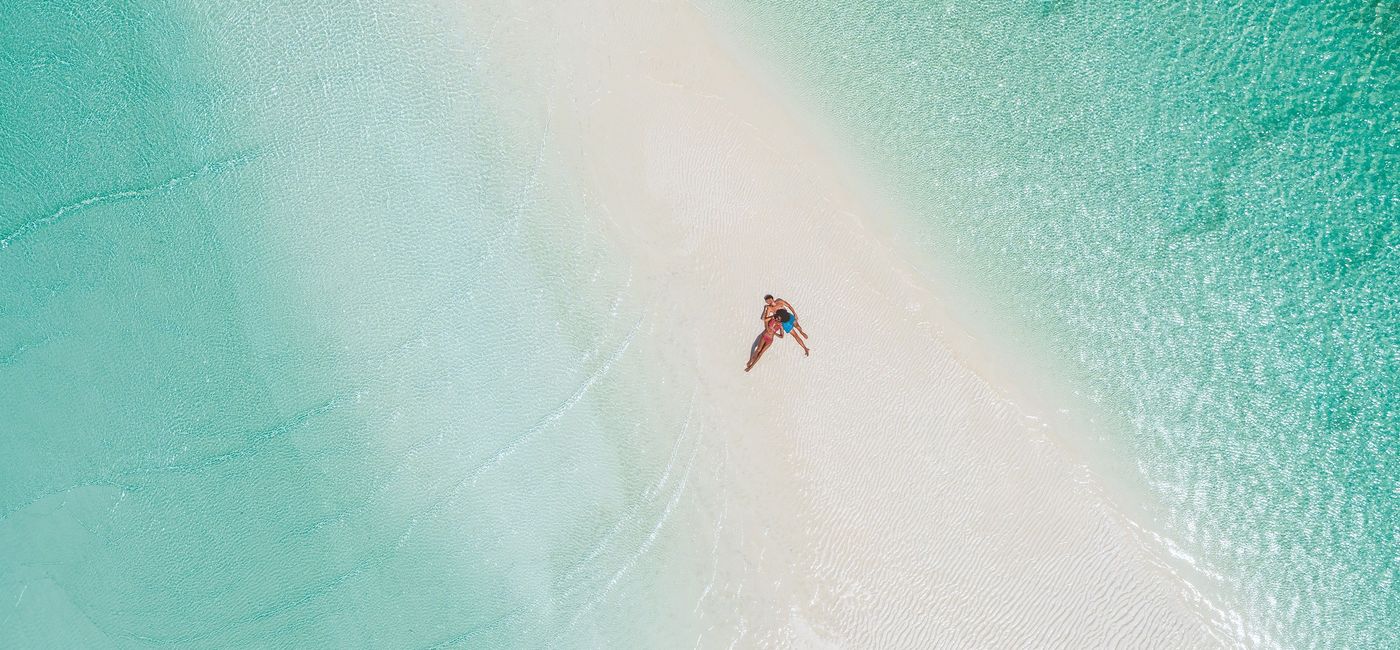 Image: A couple relaxing on a sandbar at Sandals Royal Bahamian. (photo via Sandals Resorts)