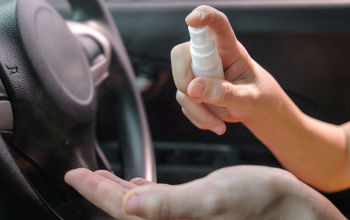 A woman using hand sanitizer before driving a rental car