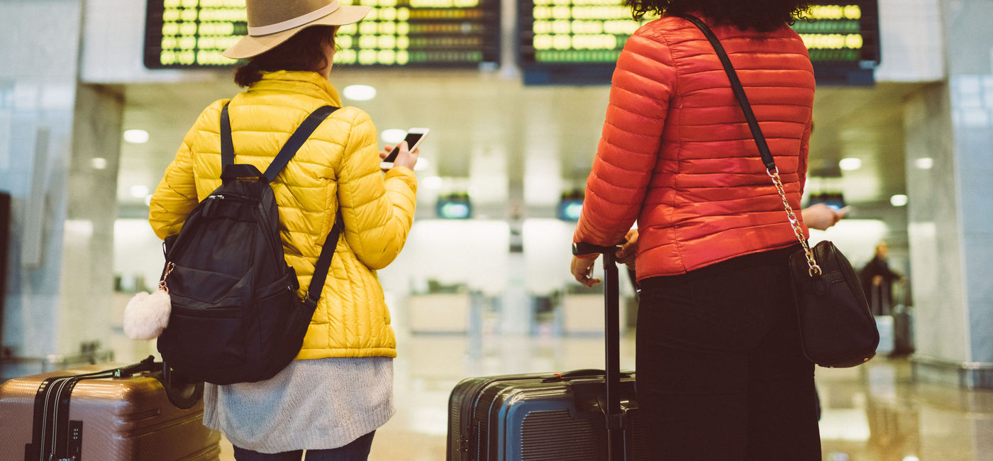 Image: Tourists at the airport waiting for the flight to be announced on the arrival departure board (Photo Credit: martin-dm / Getty Images)