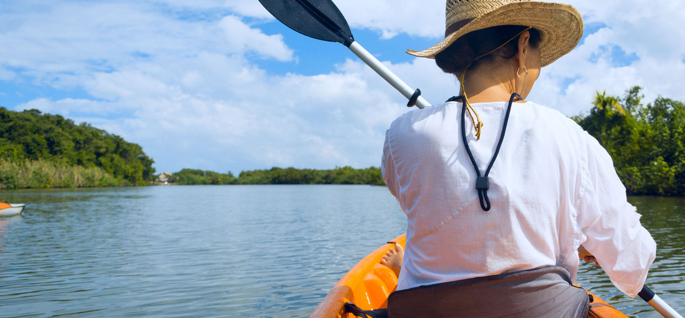 Image: PHOTO: Woman kayaking on a river in Belize. (photo via iStock / Getty Images Plus / Roijoy)