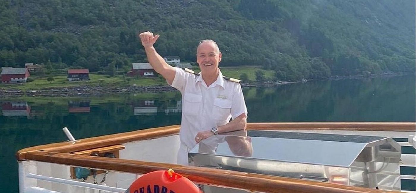 Image: Christophe Cornu, SeaDream's executive hotel manager, waves from the deck of SeaDream I before it began sailing in Norway. (Courtesy of SeaDream Yacht Club)