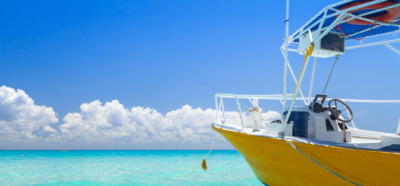 Image: PHOTO: Yellow speedboat on the beach of Playacar at Caribbean Sea of Mexico. (photo via Mustang_79 / iStock / Getty Images Plus)