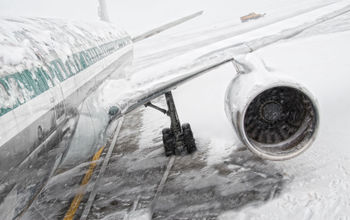 Airplane covered in snow and ice during a winter storm.