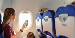 Passenger using wireless headphones on plane.