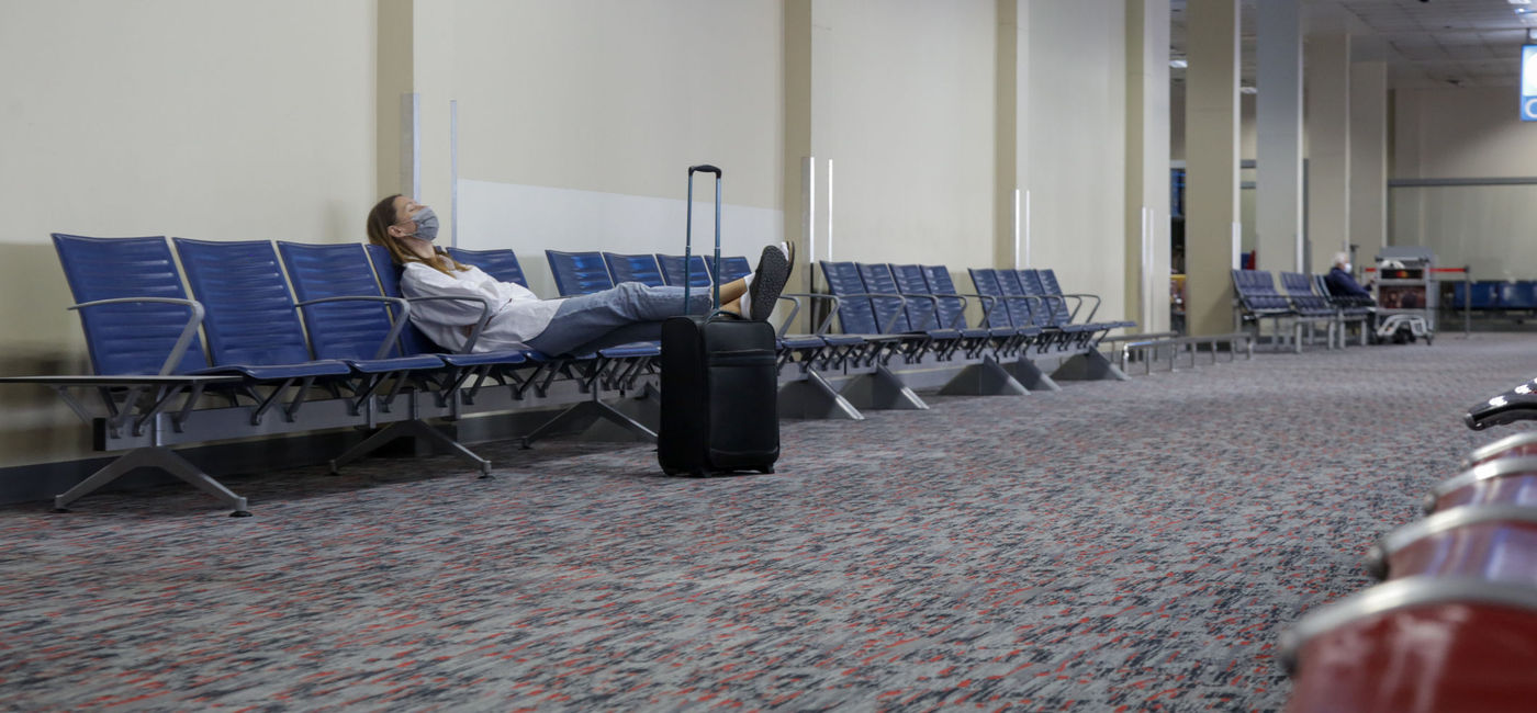 Image: PHOTO: Woman waiting at empty airport. (photo via triocean / iStock / Getty Images Plus)