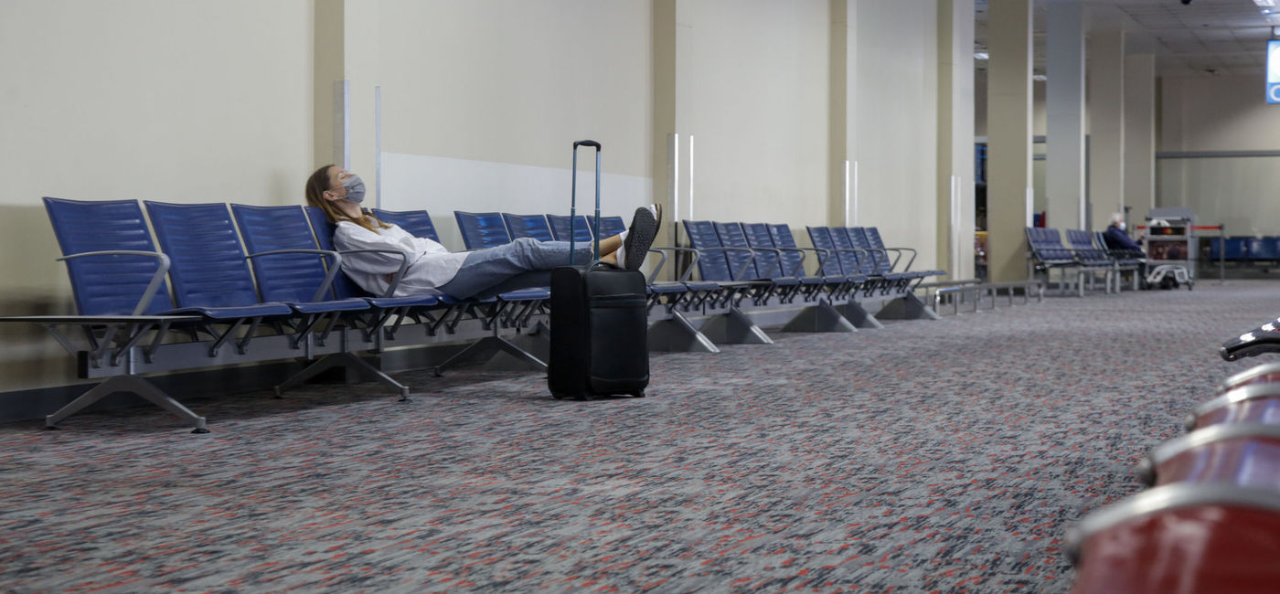 Image: Woman waiting at empty airport. (triocean / iStock / Getty Images Plus)