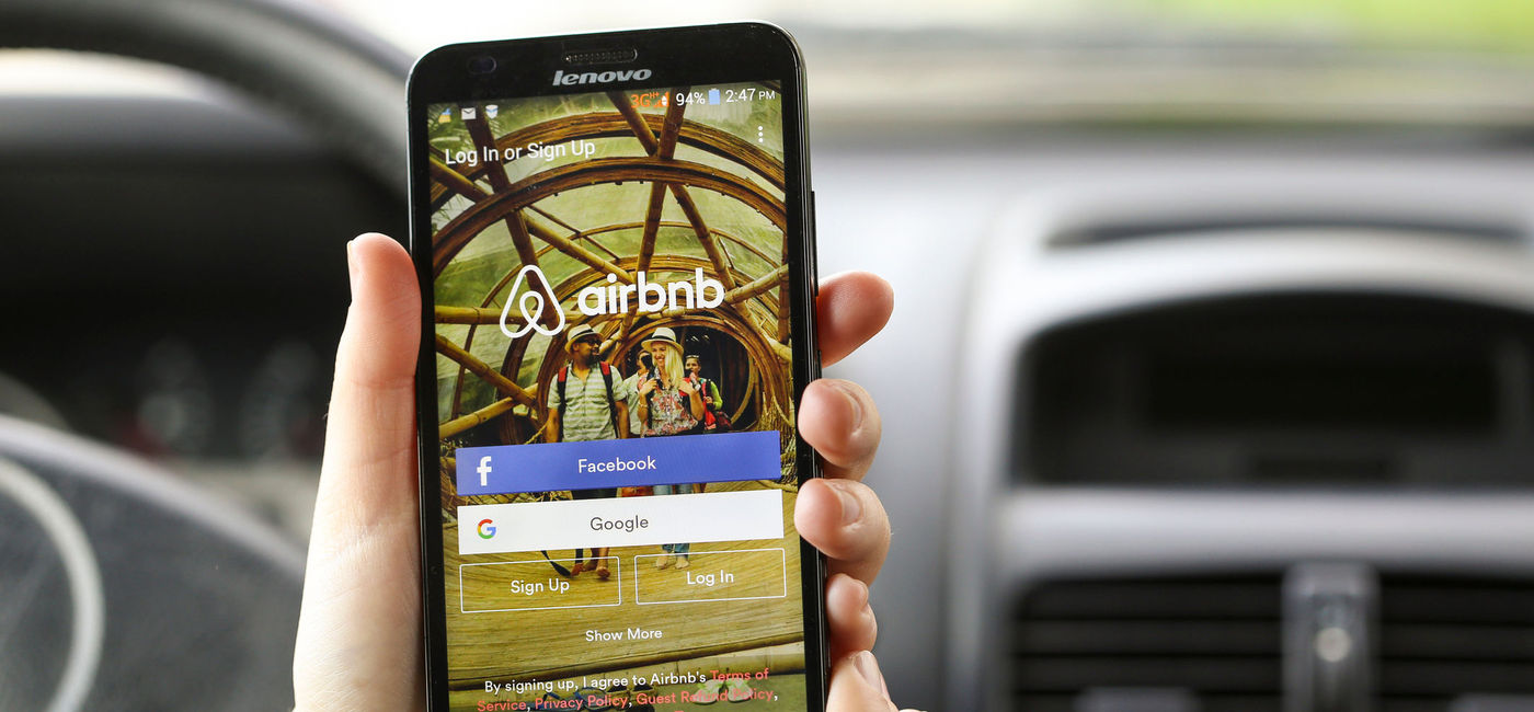 Image: Traveler using the Airbnb mobile app. (photo via GoodLifeStudio/iStock/Getty Images Plus).