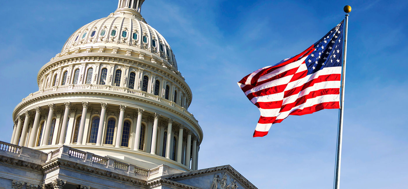 Image: American flag waving in front of the U.S. Capitol. (photo via rarrarorro / iStock / Getty Images Plus)