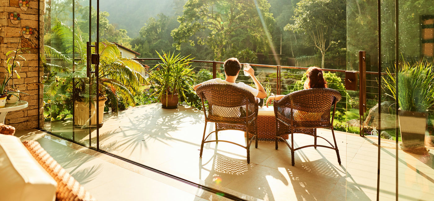Image: Couple relaxing in the chairs at hotel balcony. (photo via AJ_Watt / E+)