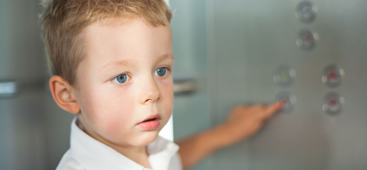 Image: Small child using an elevator. (photo via iStock/Getty Images Plus/JanKangurowski)