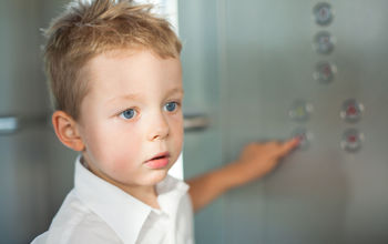 Small child using an elevator.