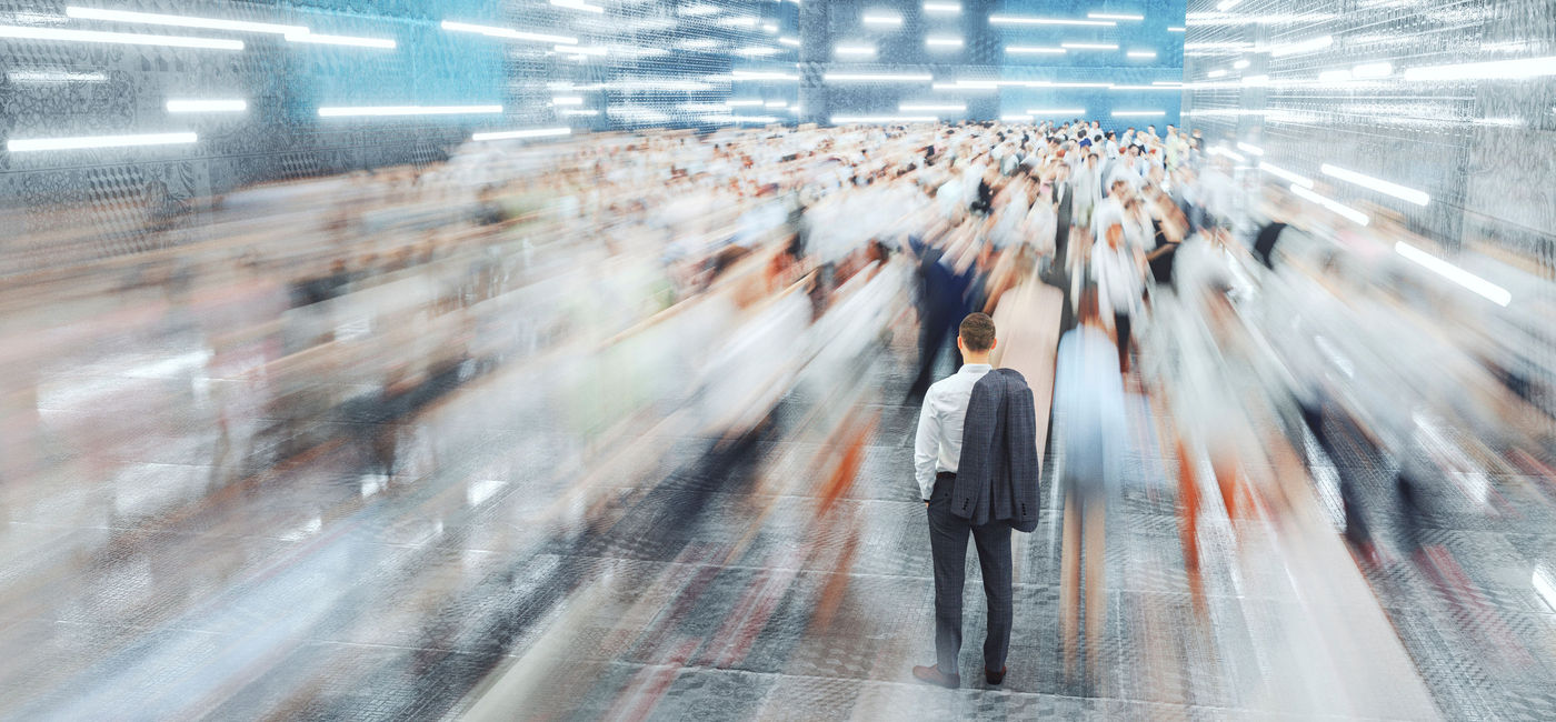 Image: A man standing amid a crowd of airport passengers. (photo via iStock/Getty Images E+/gremlin)