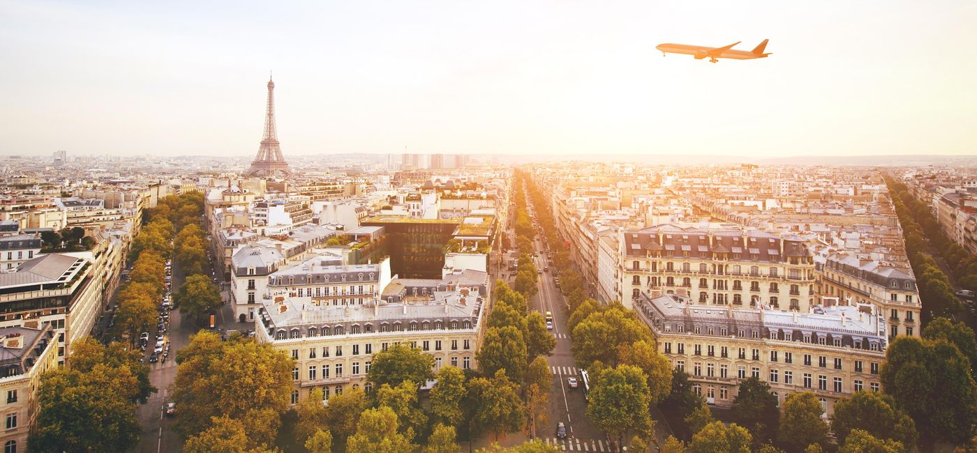 Image: airplane flying over cityscape of Paris with Eiffel Tower (Photo via anyaberkut / iStock / Getty Images Plus)