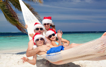 Family wearing Santa hats on a tropical beach